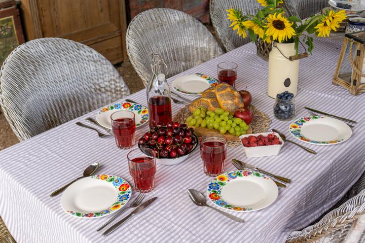 Stół nakryty łowickimi talerzami, gotowy na przyjęcie gości.