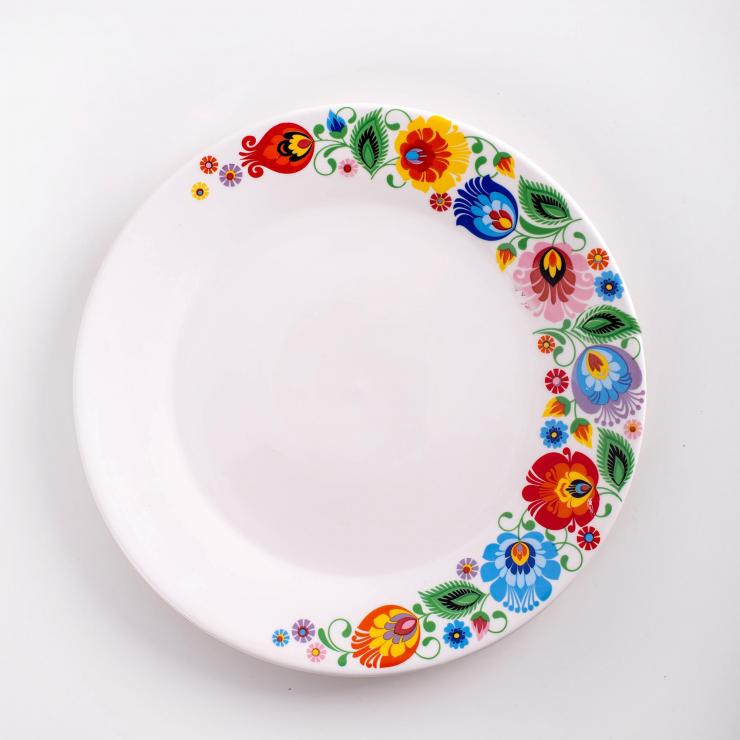 Folk white plate for main course, decorated with colorful Lowicz flowers. Part of a set of 18 pieces.