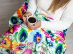 woman wrapped in a white folk blanket holding a cup of coffee